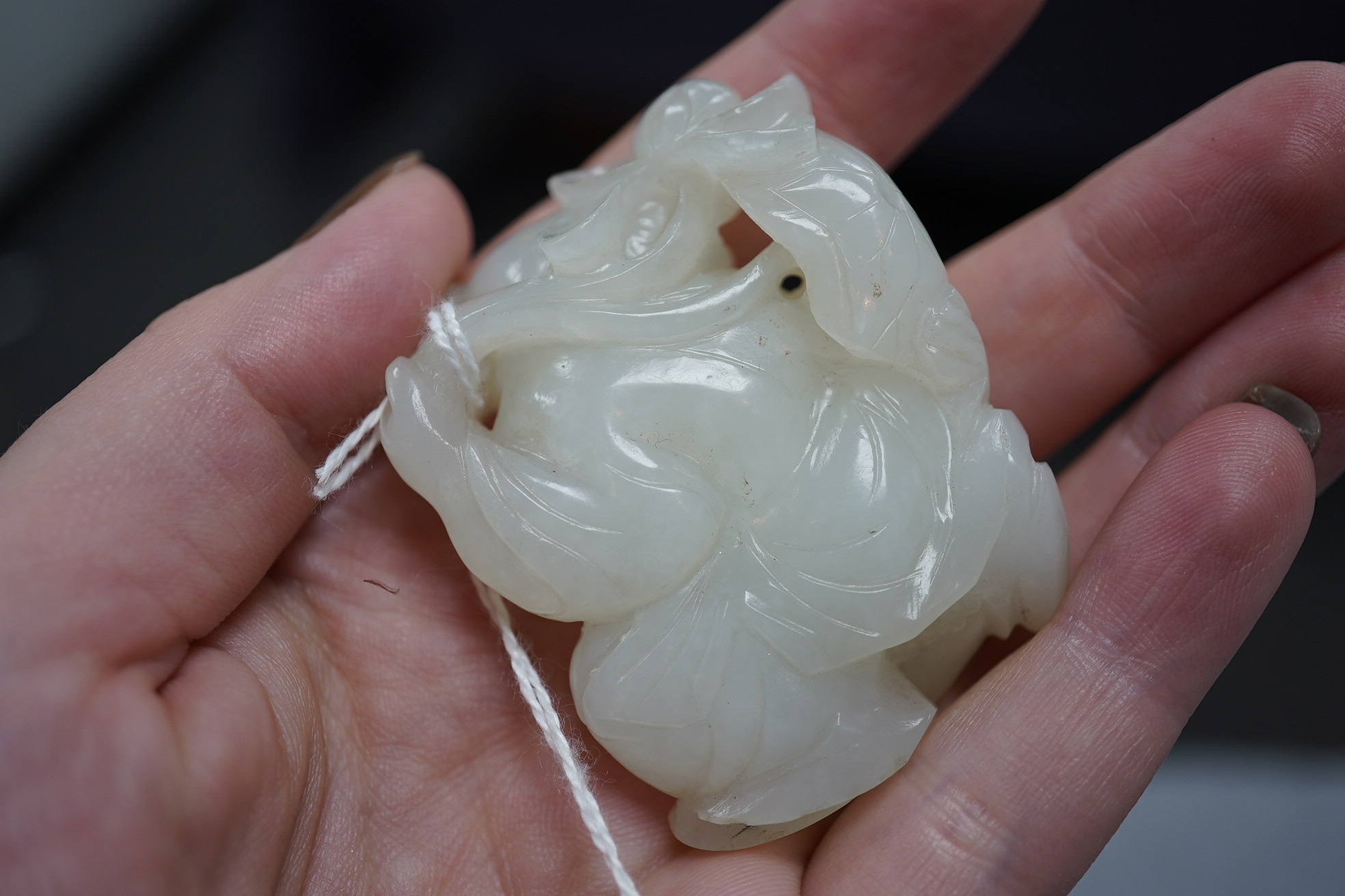 A Chinese white jade figure of a kneeling boy holding lingzhi fungus, 19th century